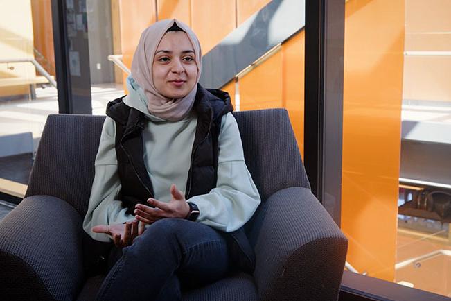 Mariam in a chair on campus