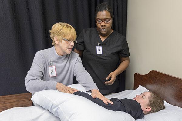 Nursing student and a professor working on a patient